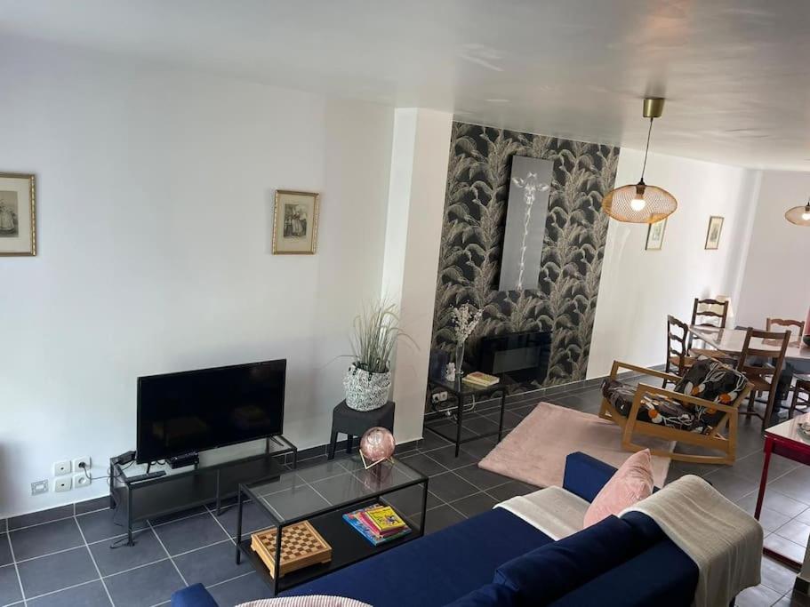 sala de estar con sofá azul y TV en LA VAGUE - Brest - Lambezellec- 7 minutes des plages et du port, en Brest
