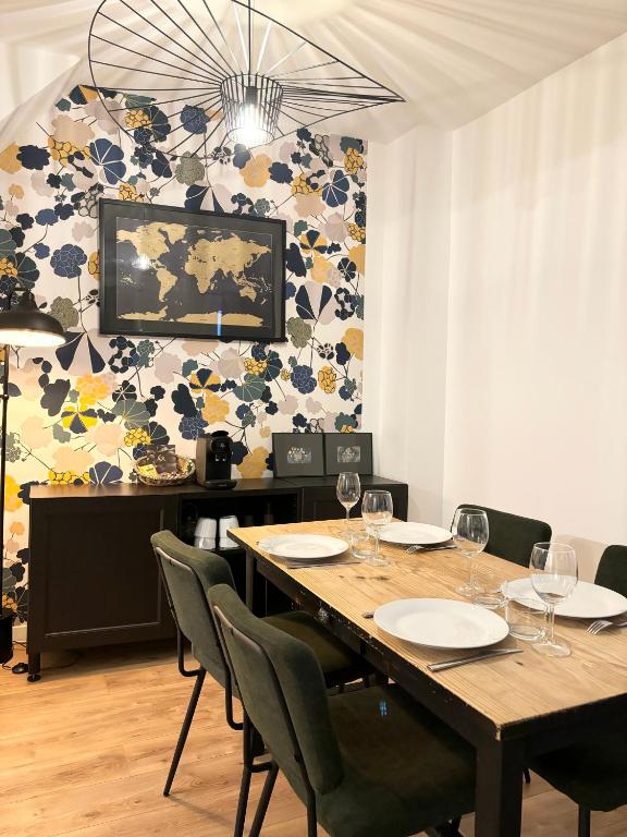 - une salle à manger avec une table, des chaises et des verres à vin dans l'établissement Petit coin de paradis proche Gare de l'Est, à Paris