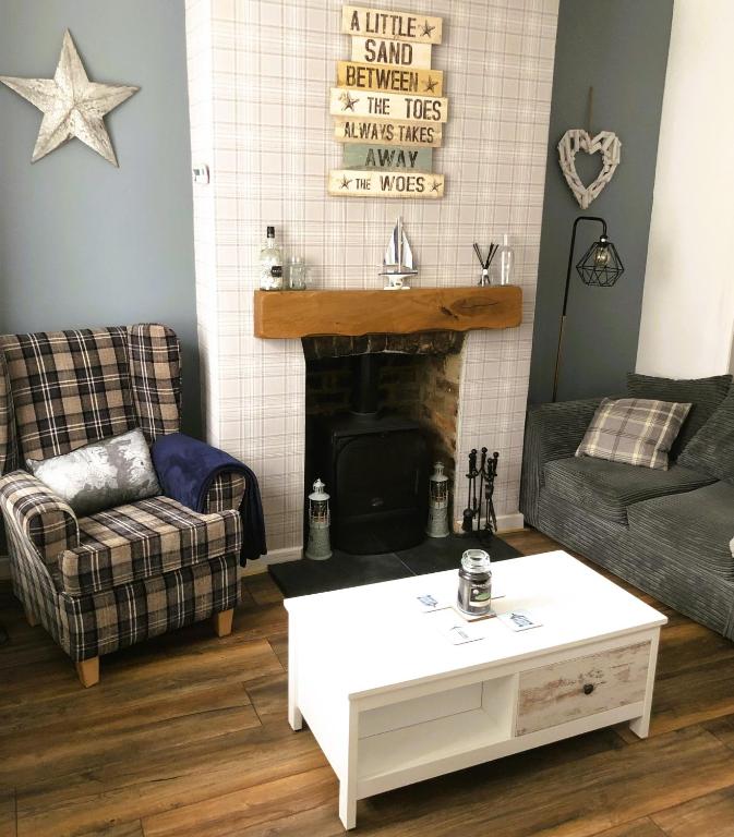 a living room with a couch and a fireplace at Kraken Cottage in Bridlington