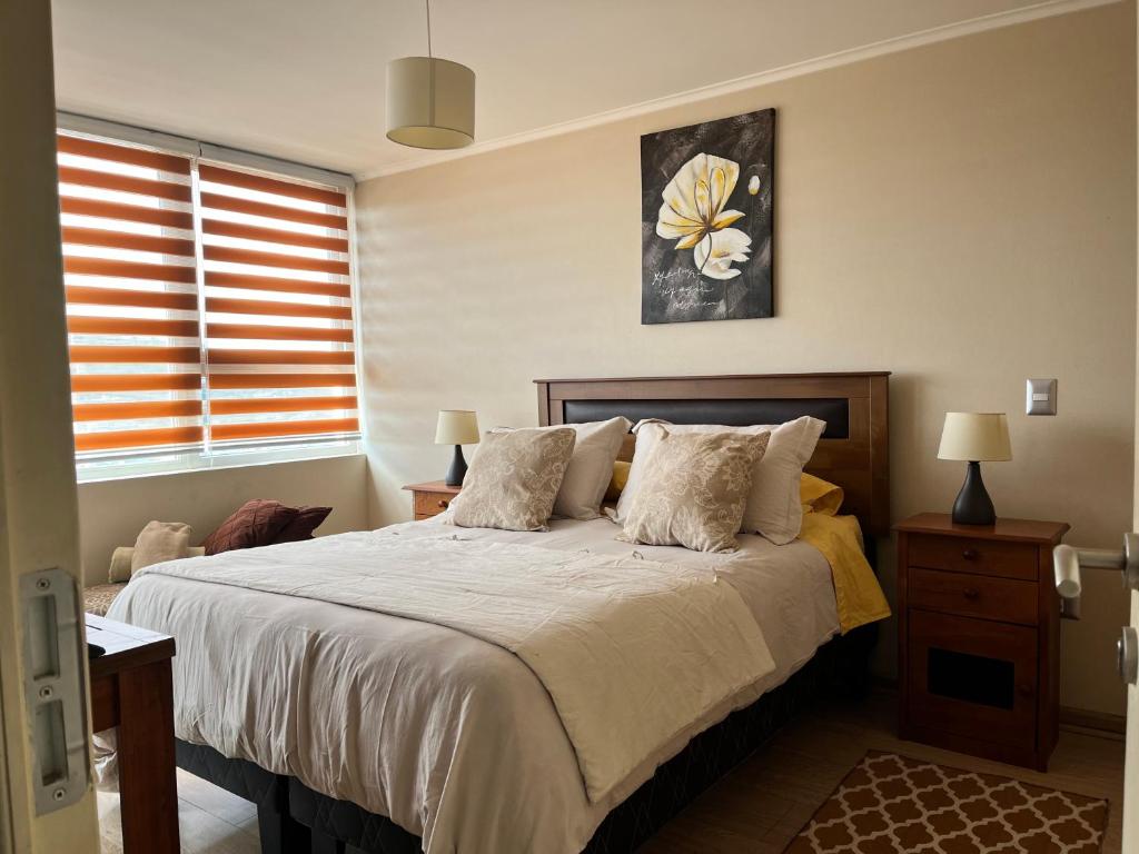 1 dormitorio con 1 cama grande y 2 almohadas en Depto 1 Dormitorio 1504 Central, en Temuco