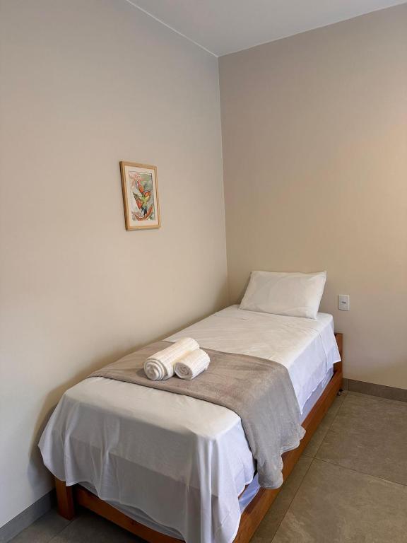 a bedroom with a bed with two towels on it at Pousada Mãe Natureza in Pirenópolis