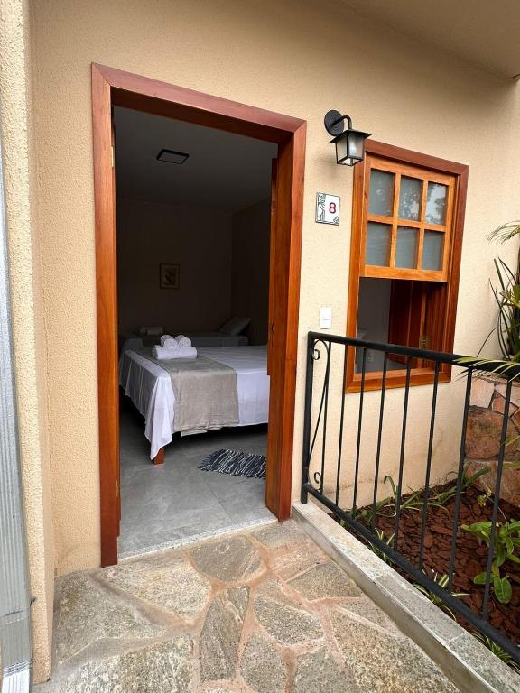 a door to a bedroom with a bed in a room at Pousada Mãe Natureza in Pirenópolis