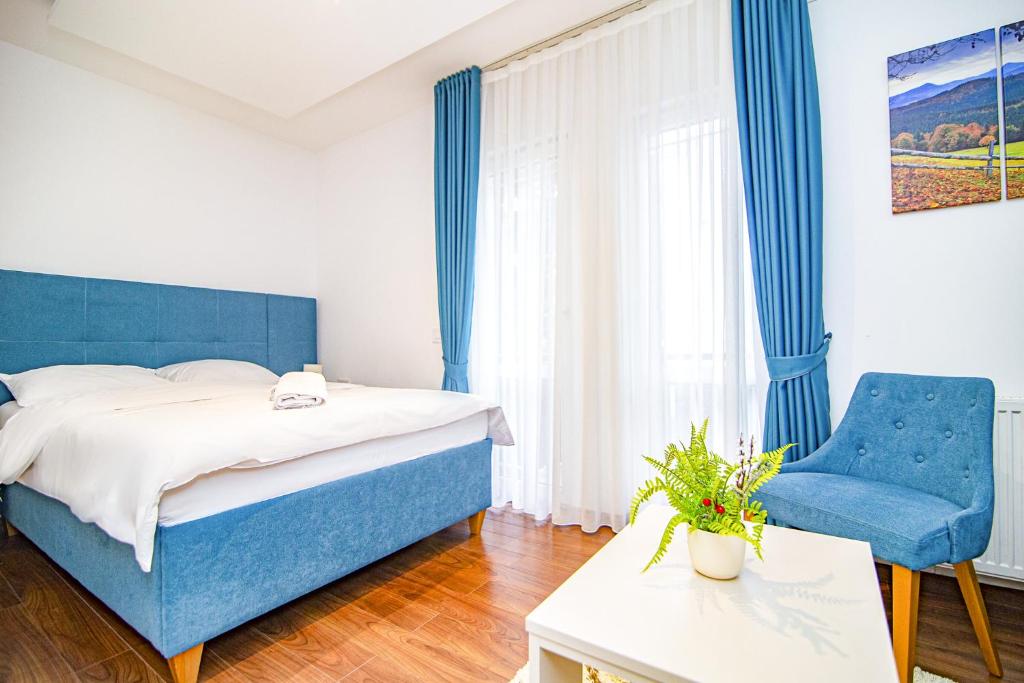 um quarto com uma cama azul e uma cadeira azul em Hotel Konačište Akustik em Zlatibor