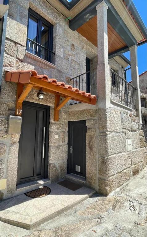 a stone house with two doors and a balcony at Casa dos Avós in Avelal