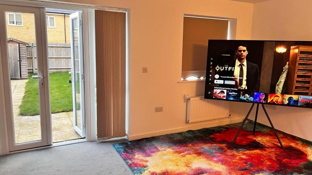 a flat screen tv on a stand in a living room at Pristine 3-Bed House in Grays in West Thurrock