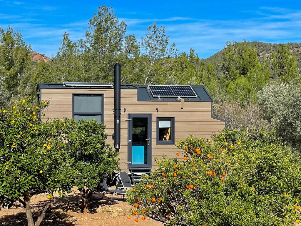 une petite maison avec des panneaux solaires sur le toit dans l'établissement Tiny House 'la Huerta', à Montroy