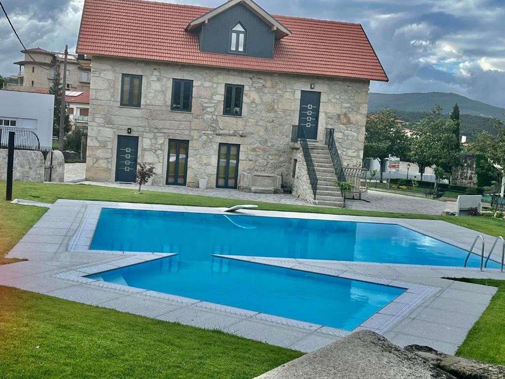 una gran piscina azul frente a un edificio en Casa das Varzielas, en Mondim de Basto