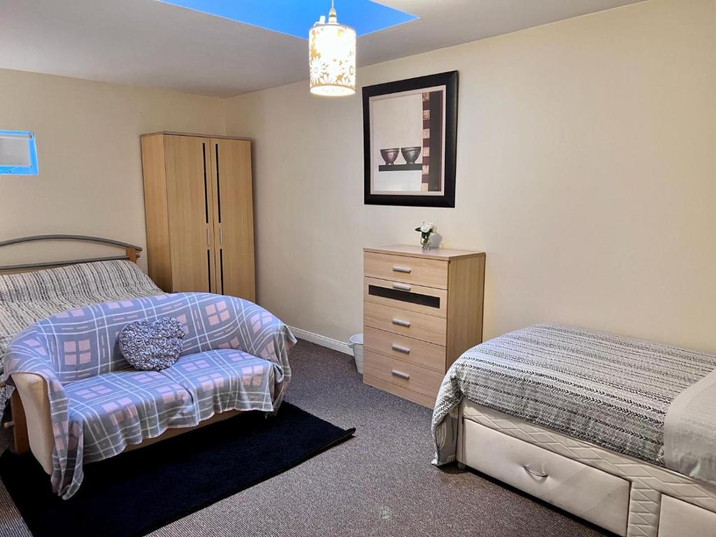 ein Schlafzimmer mit einem Bett, einer Kommode und einem Bett sidx sidx sidx sidx sidx in der Unterkunft Prestashortstays in Belfast