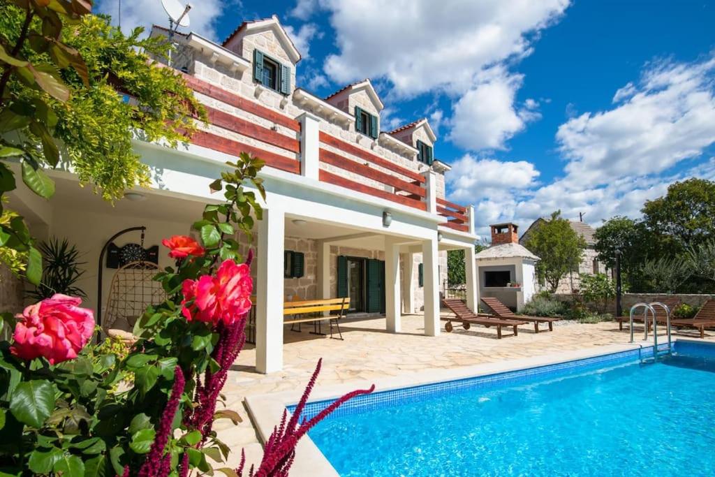 an exterior view of a house with a swimming pool at Villa Ivana in Zmijavci