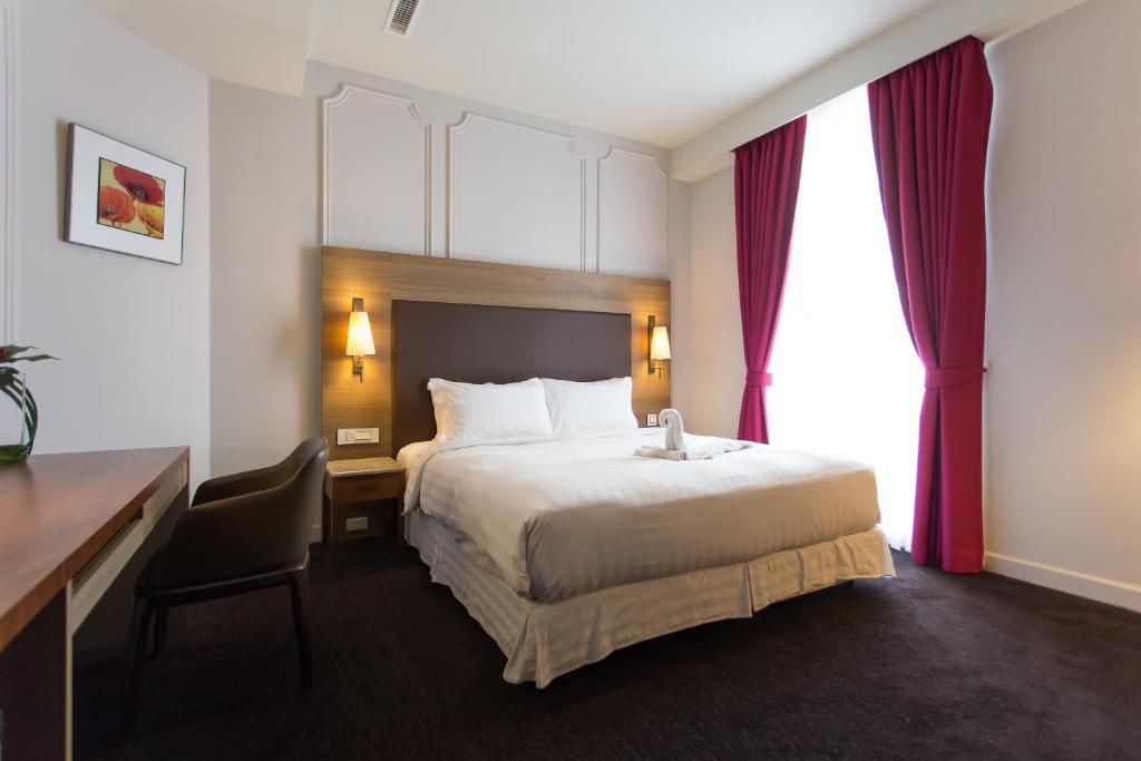 高雄的住宿－麗馨商旅七賢館，酒店客房设有一张大床、一张书桌和一张书桌。