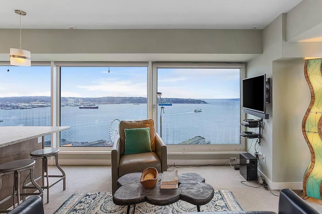 a living room with a view of the water at NewMark Tower’s Water Wheel Condo with Sea Views in Seattle
