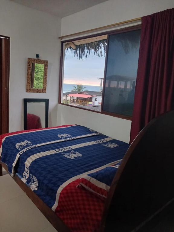 ein Schlafzimmer mit einem Bett und einem großen Fenster in der Unterkunft 3 Floor Seawiew in Montañita