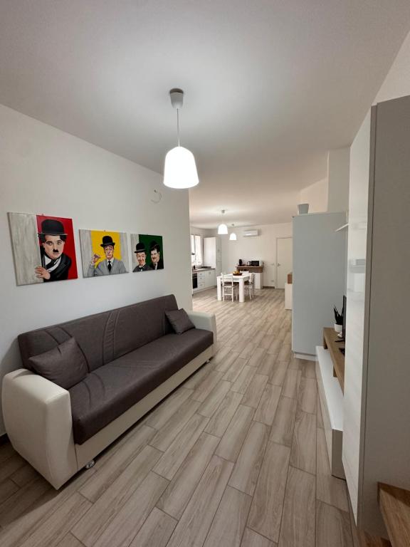 ein Wohnzimmer mit einem braunen Sofa in einem weißen Zimmer in der Unterkunft Casa Andrew in Terrasini