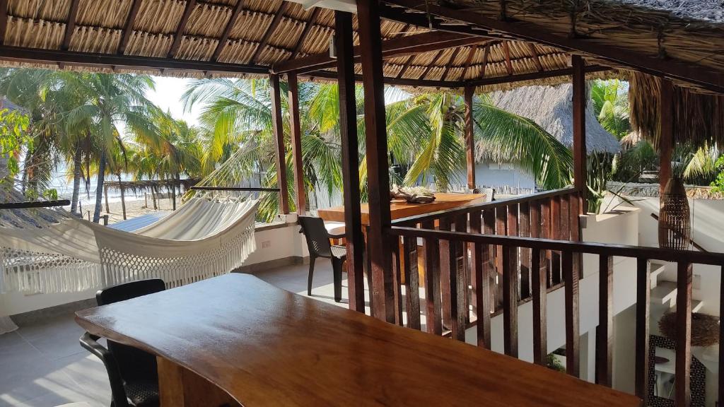 porche con mesa, sillas y vistas al océano en Rincón del mar Hotel Boutique los Veleros en San Onofre