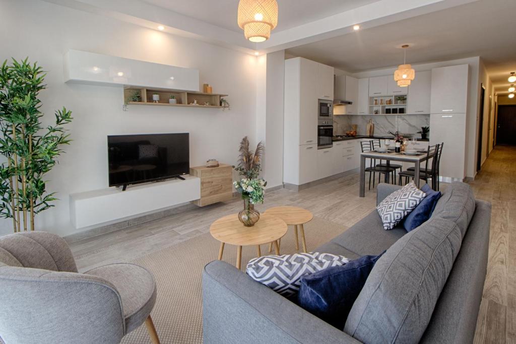 ein Wohnzimmer mit einem Sofa und einem TV in der Unterkunft Bright 2 Bedroom 2 Bath Apartment close to sea in St Paul's Bay