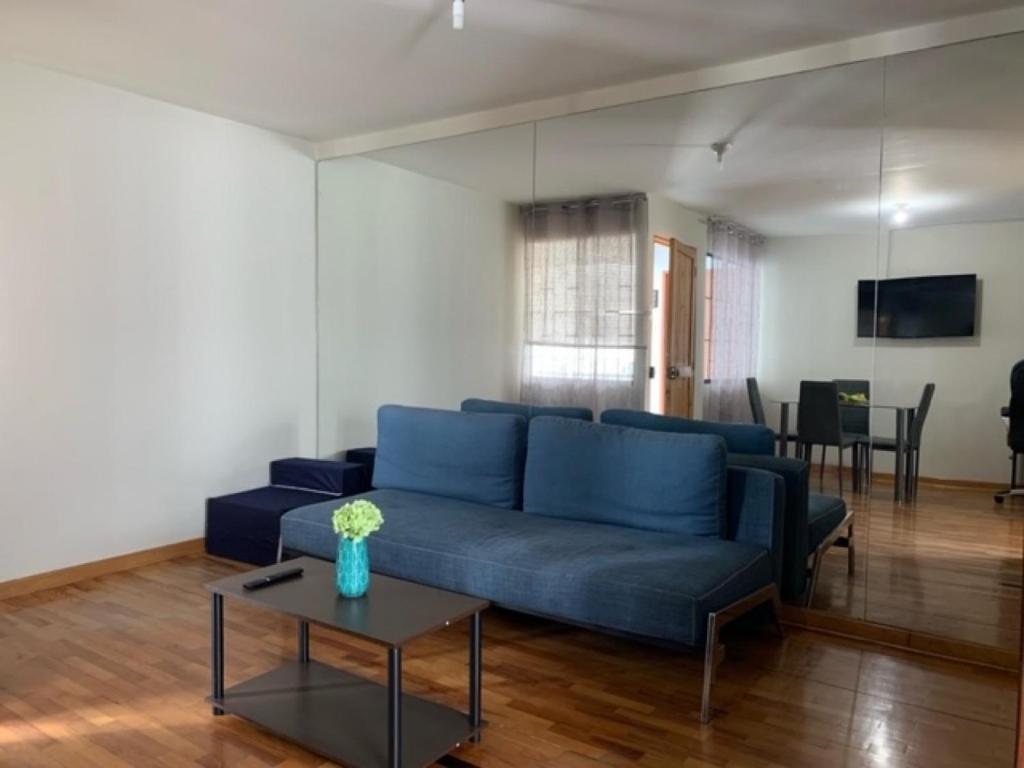 a living room with a blue couch and a table at Costa Verde 2 Bedrooms Apartment Miraflores in Lima