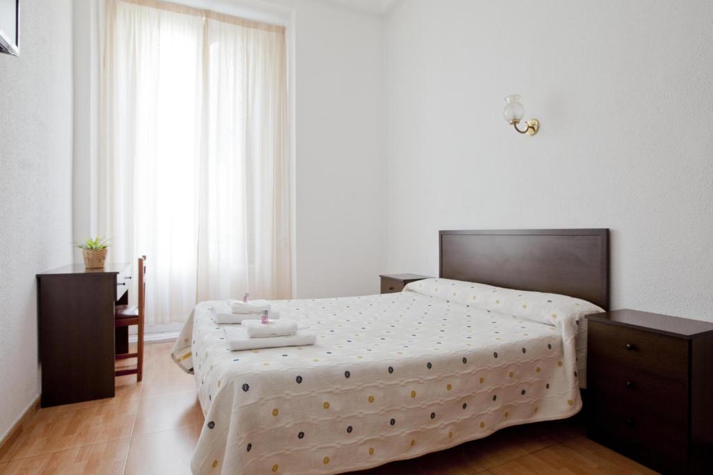 1 dormitorio con 1 cama grande y suelo de madera en Hostal Condestable, en Madrid