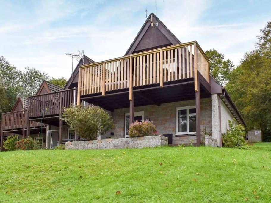 a house with a large deck on top of a field at 24 Valley Lodge Holiday Cottage in Callington