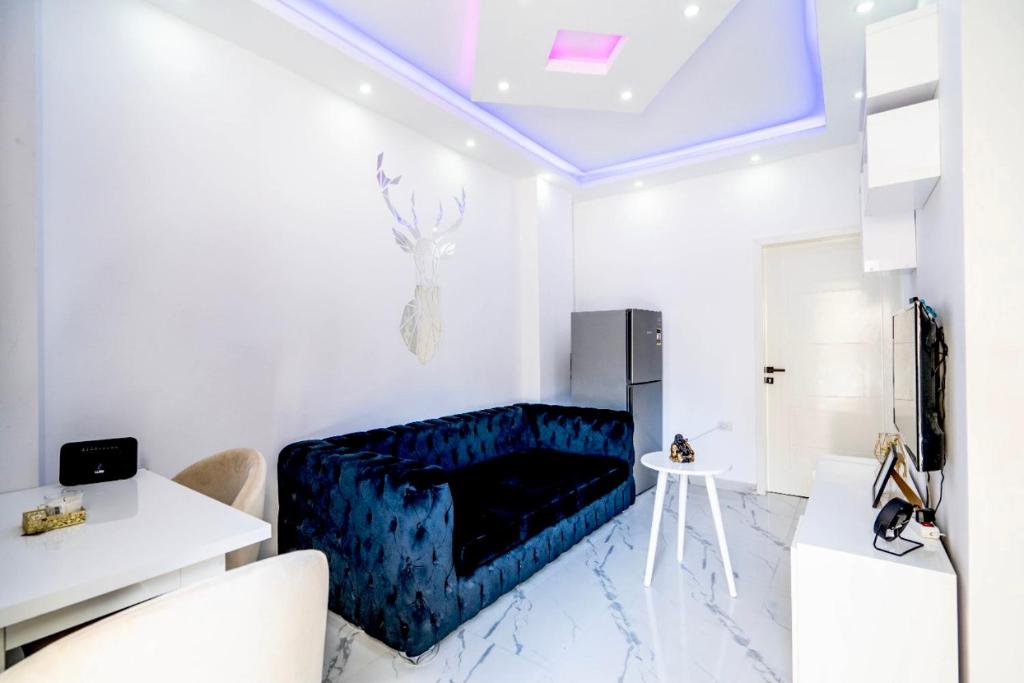 a living room with a blue couch in a white room at Hurghada apartment luxury 001 in Hurghada