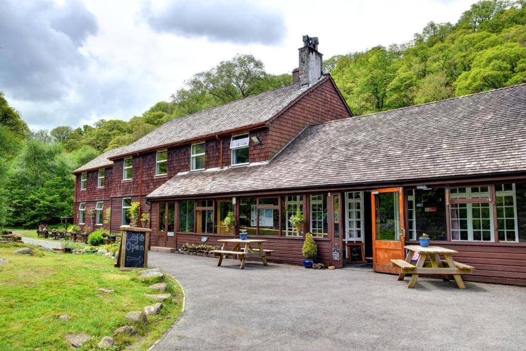 un edificio con bancos y mesas delante de él en YHA Borrowdale, en Rosthwaite