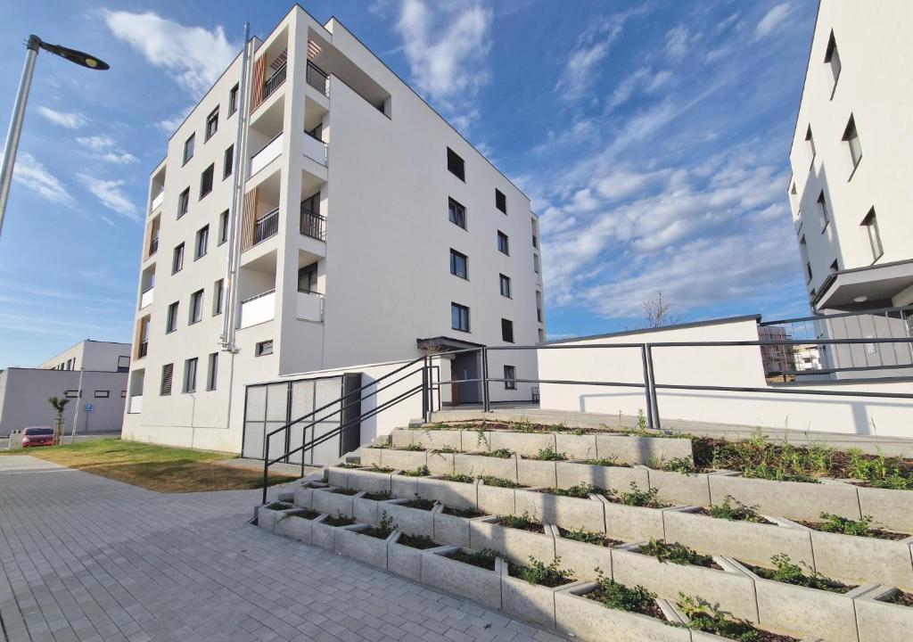 - un bâtiment blanc avec des escaliers devant dans l'établissement VIA Apartmany, à Trenčín