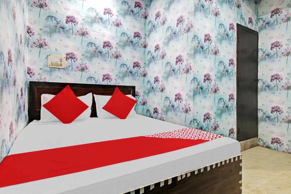 a bedroom with a bed with red pillows and floral wallpaper at OYO Hotel Dream Town 2 in New Delhi