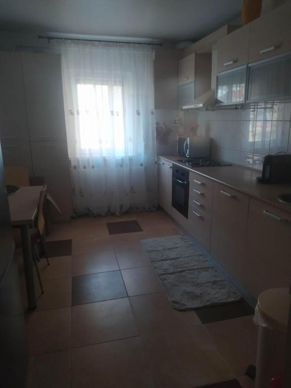 een keuken met witte kasten en een raam bij Apartament Bulevardul Oltenia in Craiova