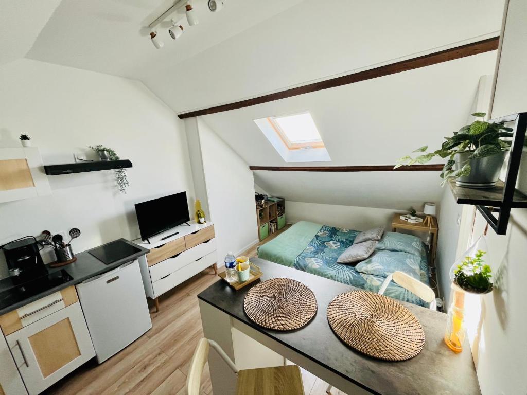 une petite pièce avec un lit et une table dans l'établissement Le Studieux Abbevillois, à Abbeville