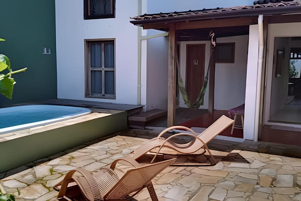 a patio with two chairs and a swimming pool at Espaço Luz in Paraty