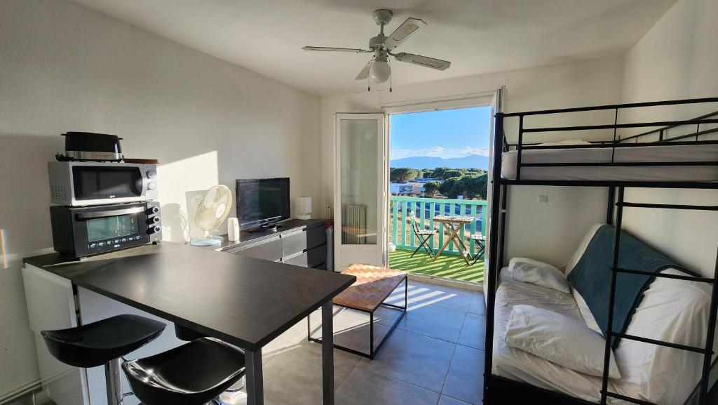 een slaapkamer met een stapelbed en een tafel en stoelen bij Studio et parking avec plage à 350m in Canet-en-Roussillon