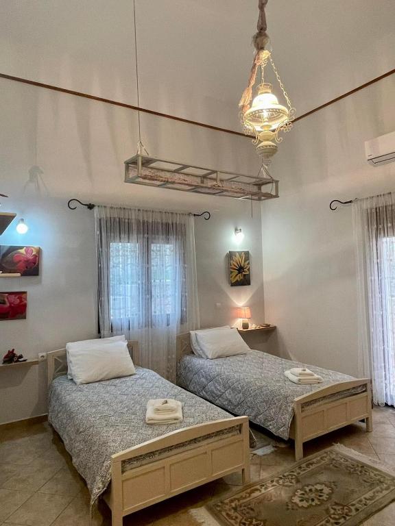 sypialnia z 2 łóżkami i żyrandolem w obiekcie VILLA NEXT TO THE SEA!! w mieście Kalimnos