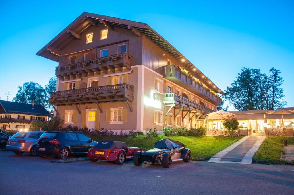 a large building with cars parked in front of it at Hotel Schlossblick Chiemsee in Prien am Chiemsee