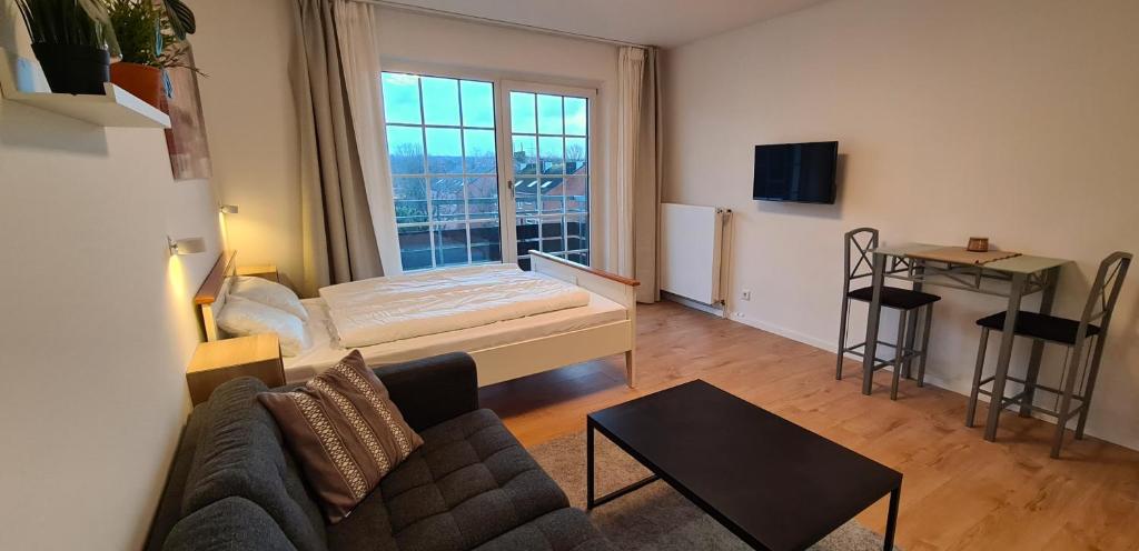 ein Wohnzimmer mit einem Sofa und einem Bett in der Unterkunft Renoviertes Apartment inkl TG Stellplatz in Düsseldorf in Düsseldorf