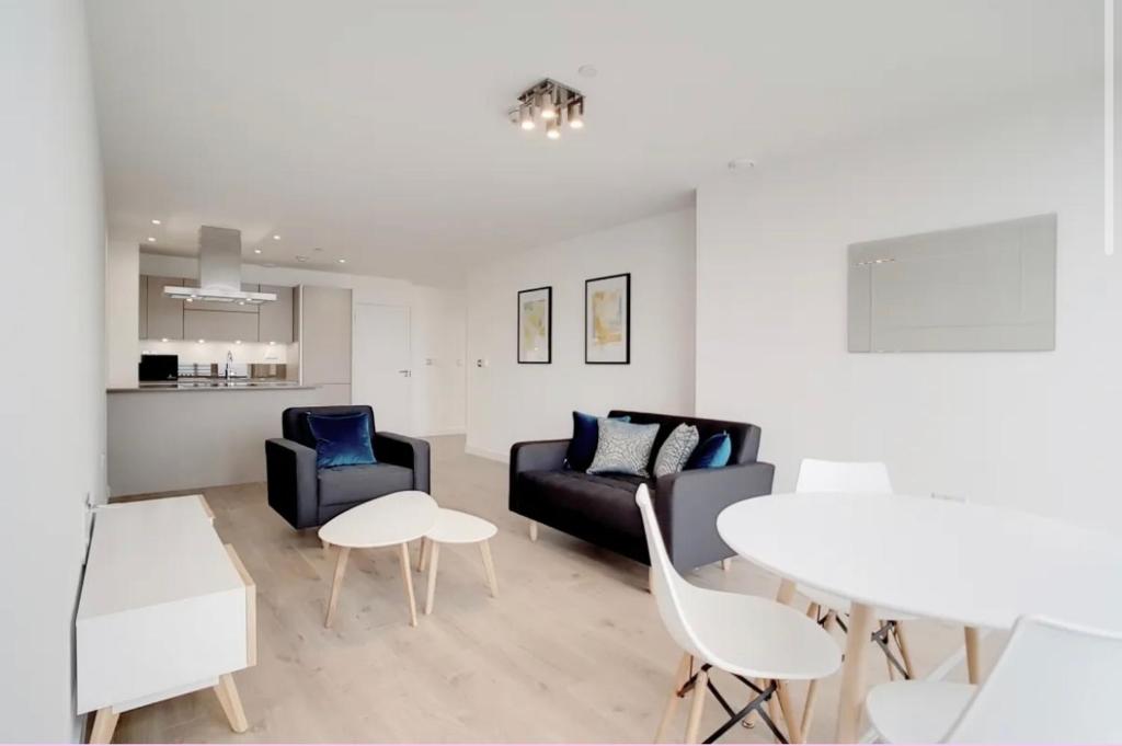 a living room with a couch and chairs and a table at 1 Bedroom Apartment Stratford in London