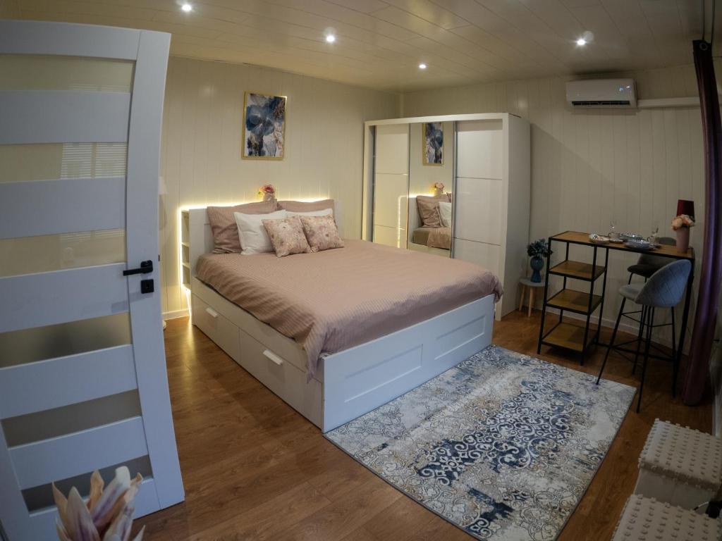a bedroom with a bed and a desk and a mirror at Apartament Classic Comfort Aleja NMP 8 - Free parking in Częstochowa