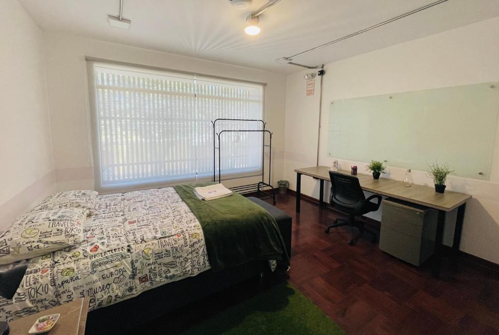 a bedroom with a bed and a desk and a chalkboard at Idea Home in Lima