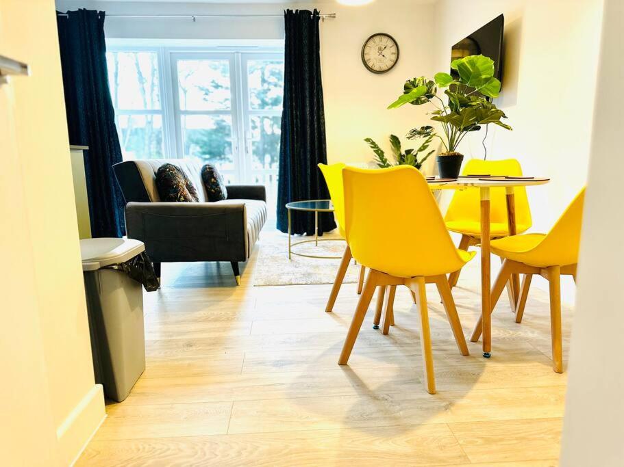 a living room with a table and yellow chairs at Cosy Dover suite w Free Parking in Kent