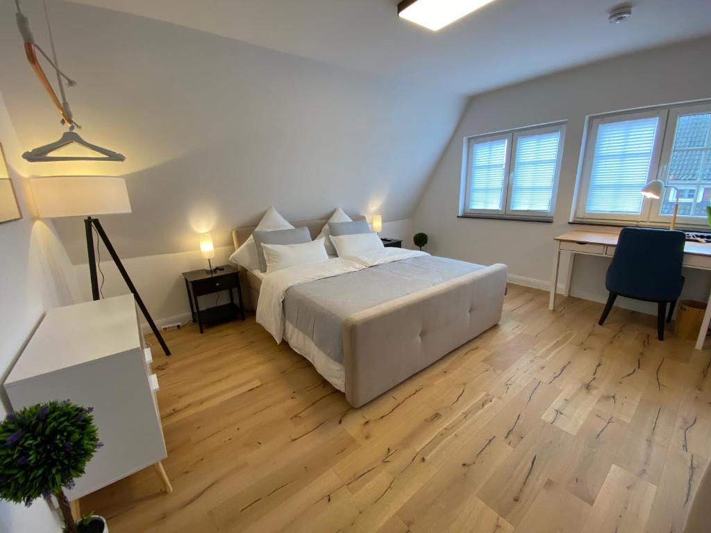 a bedroom with a large white bed and a desk at Stadtoase: Exklusive Apartments für Ruhe und Entspannung in Bremen