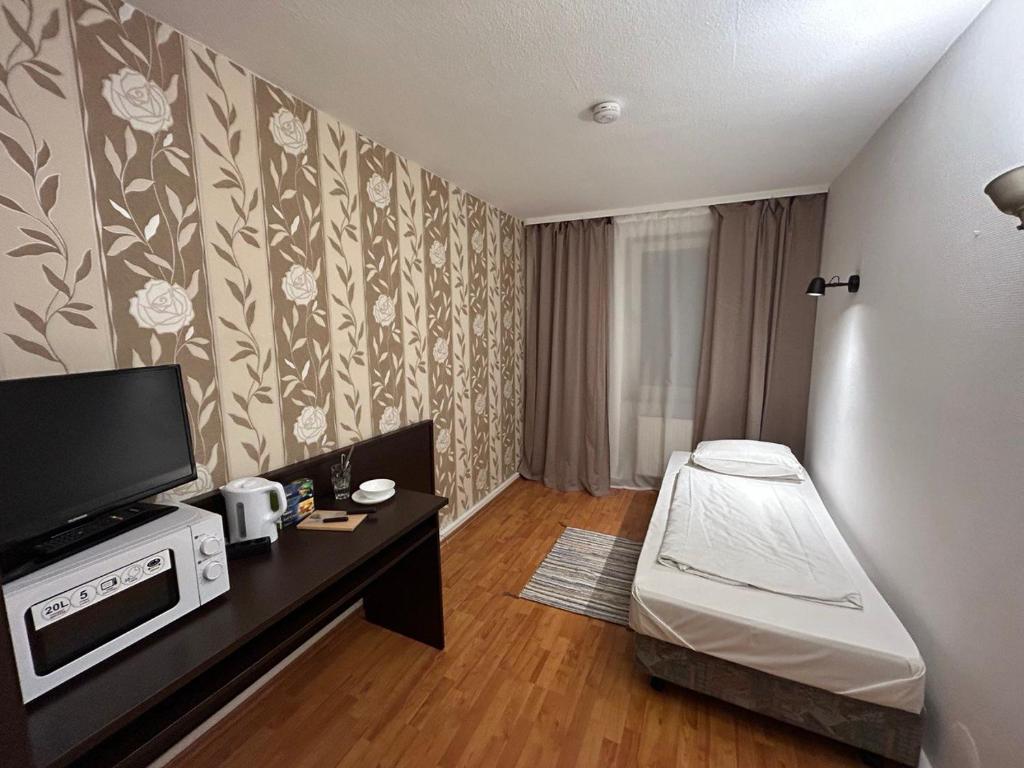 um pequeno quarto com uma cama e uma televisão em WestEnd#103 em Frankfurt am Main