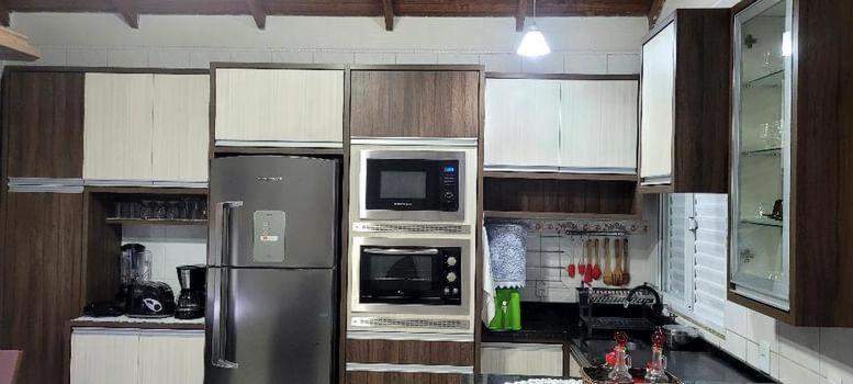 a kitchen with a stainless steel refrigerator and wooden cabinets at Aconchego Lagoinha in Florianópolis