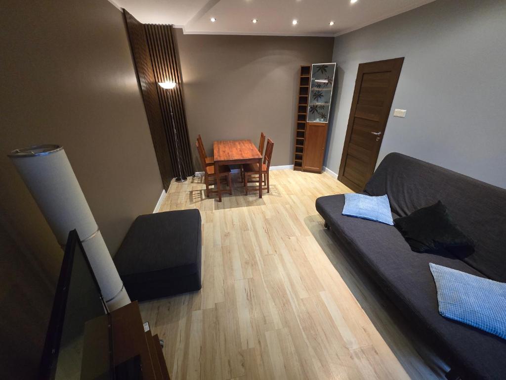 uma sala de estar com uma cama, uma mesa e cadeiras em Poza zgiełkiem miasta, a jednak wszystko w zasięgu em Bydgoszcz