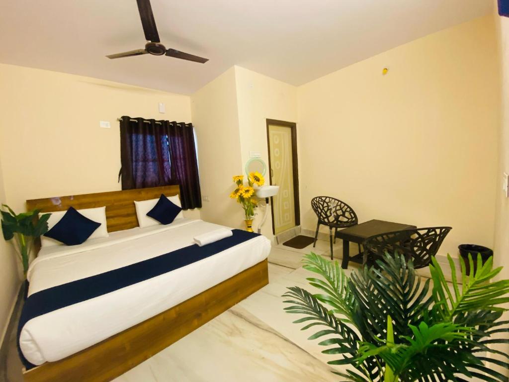 Hotel KP Suites Airport في شامشاباد: غرفة نوم بسرير وطاولة وبعض النباتات