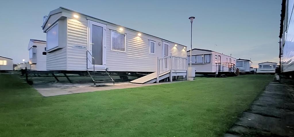 una fila de casas móviles estacionadas en un patio en Staycation Coastfields Holiday Park JG84, en Ingoldmells