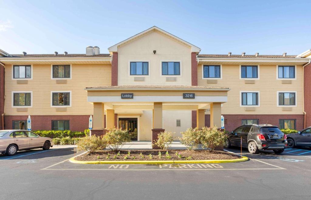 un gran edificio con coches estacionados en un estacionamiento en Extended Stay America Suites - Philadelphia - Bensalem, en Bensalem