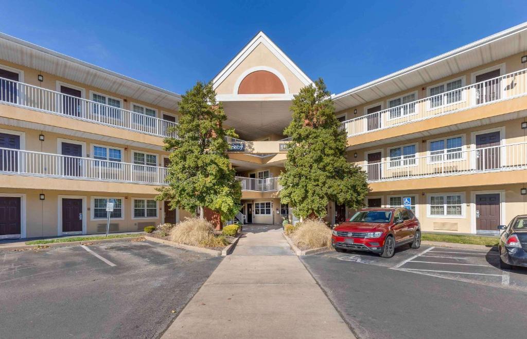 an apartment building with a car parked in a parking lot at Extended Stay America Suites - St Louis - Westport - East Lackland Rd in Maryland Heights