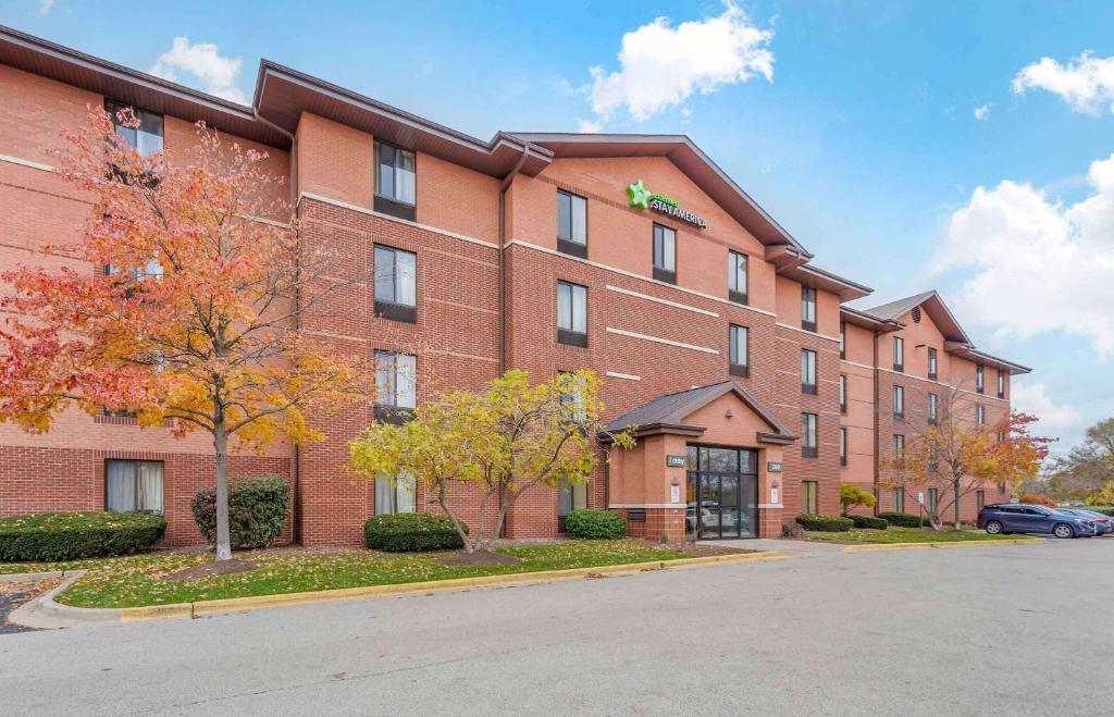 a large red brick building with a parking lot at Extended Stay America Suites - Chicago - Lombard - Yorktown Center in Lombard