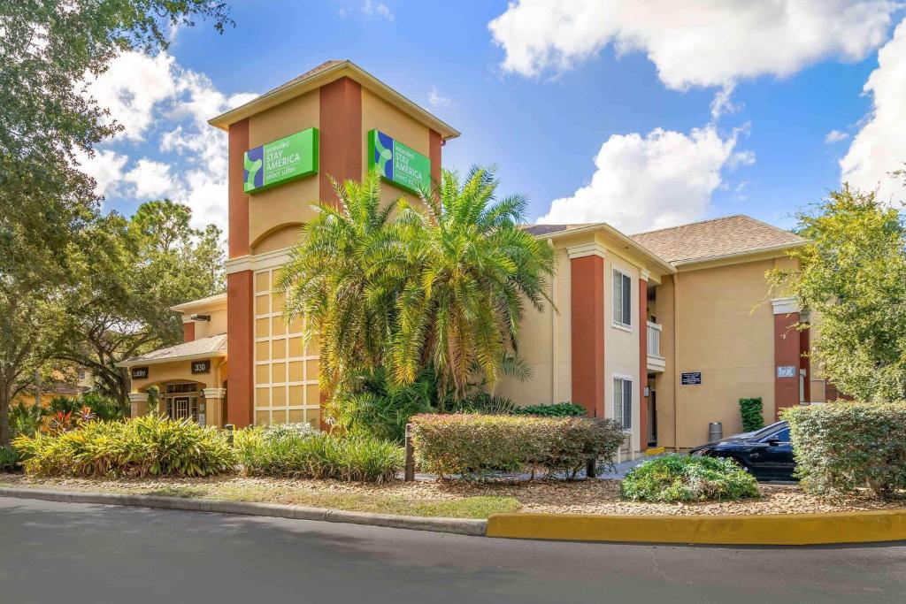 un bâtiment d'hôtel avec une voiture garée devant lui dans l'établissement Extended Stay America Select Suites - Tampa - Brandon, à Brandon