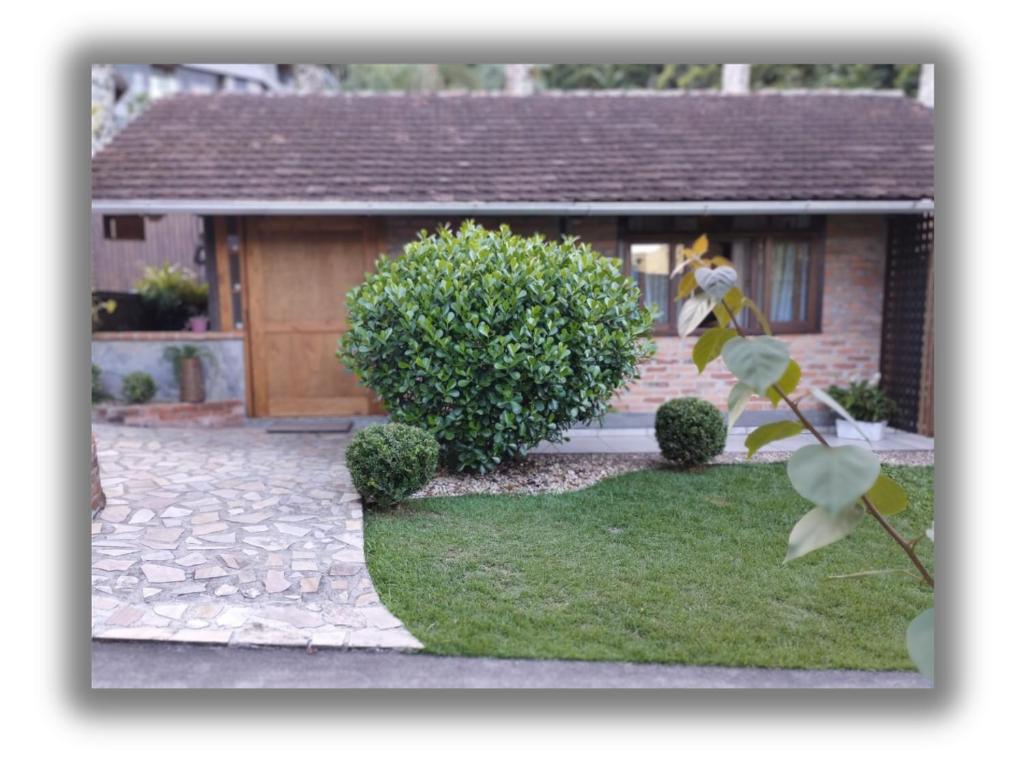 a house with a door and a grass yard at Casa da Lagoa - Gasthaus Pomerode in Pomerode
