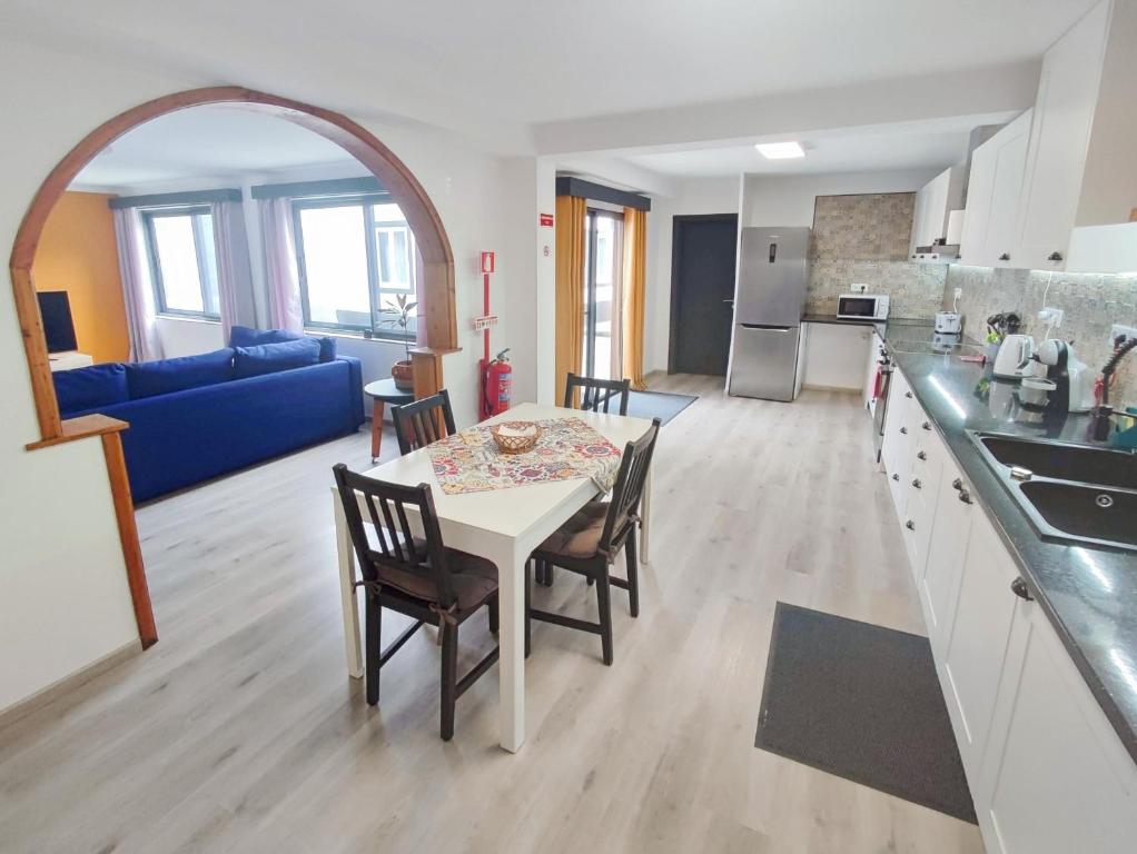 a kitchen and living room with a table and chairs at Vila Arrifes Guesthouse Downstairs in Ponta Delgada