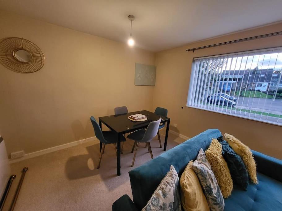 sala de estar con sofá azul y mesa en Lovely apartment with free parking & Wi-Fi en Birmingham